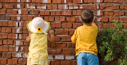 deux enfants écrivent sur un mur